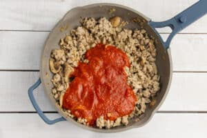 Picture of skillet with marinara sauce added.