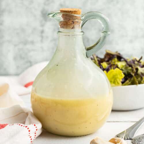 Square picture of a jar filled with champagne vinaigrette.