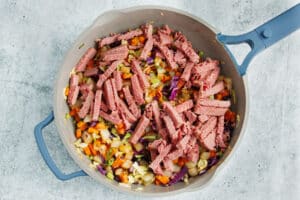 This is a picture of a skillet with the cooked veggies and corned beef added.