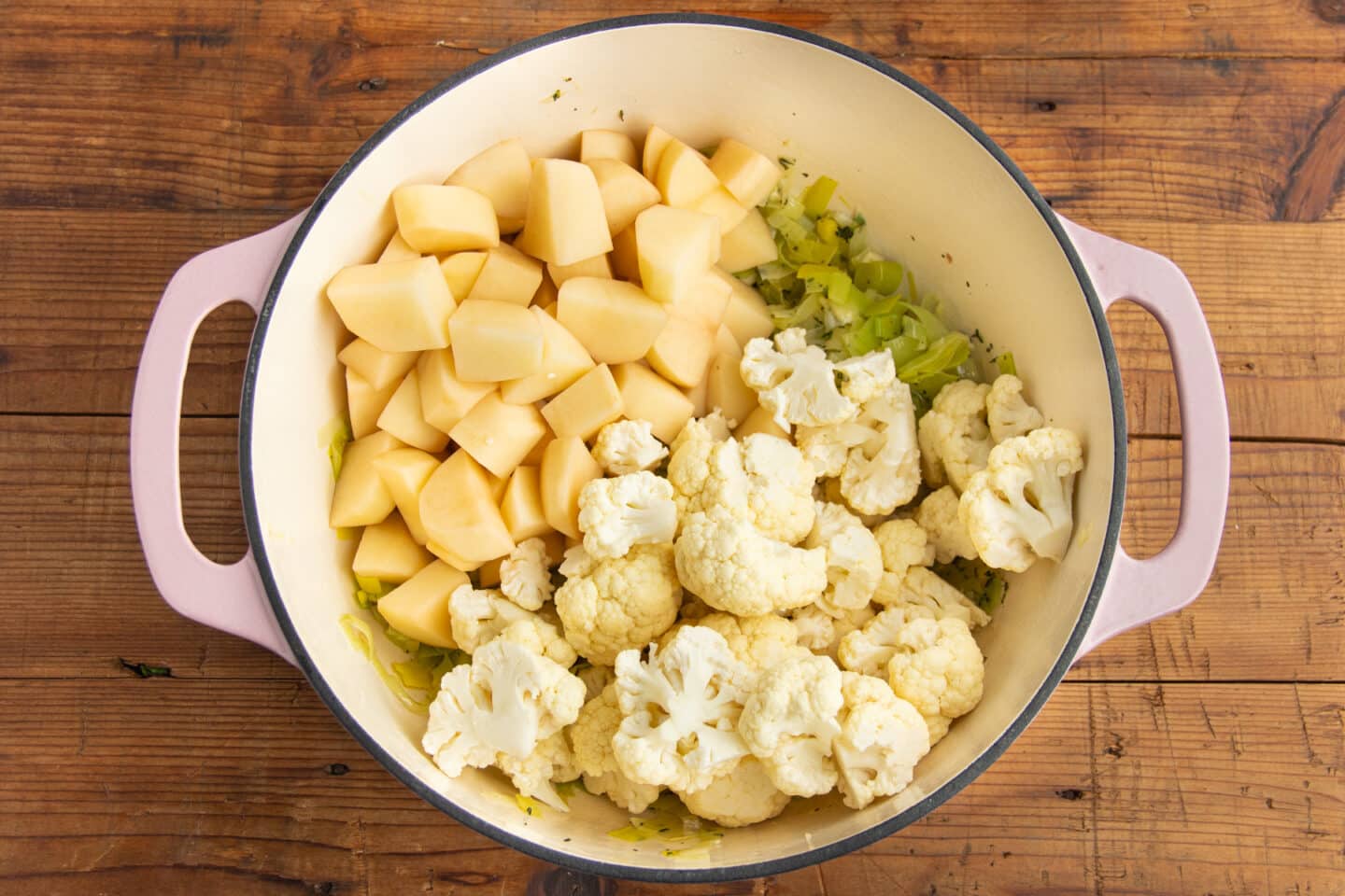 This is a picture of a big pot with leeks, cauliflower and potatoes added.