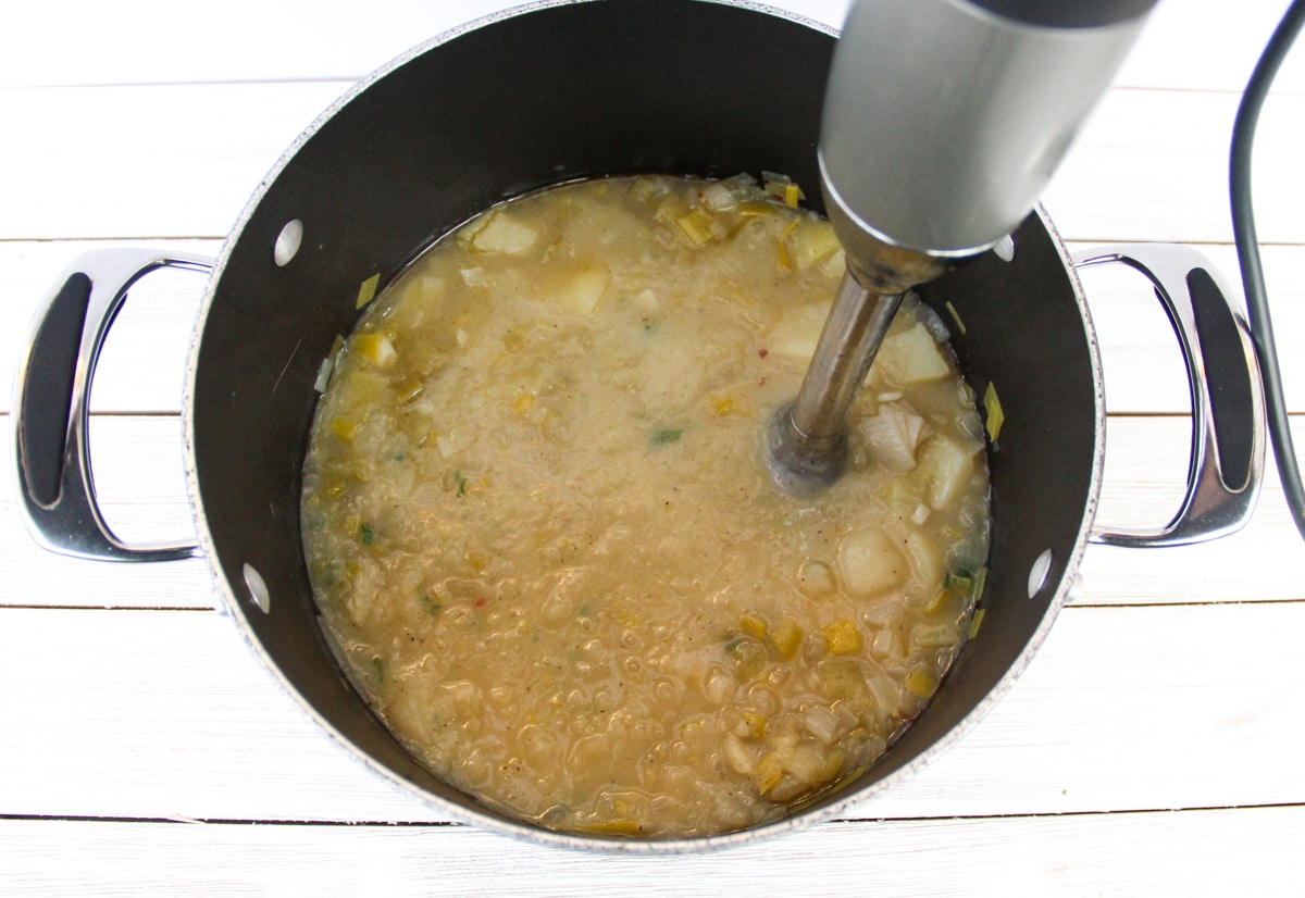 pot with food being blended with immersion blender
