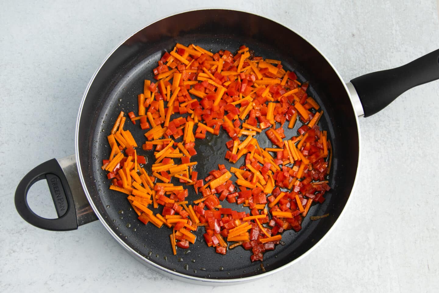 Picture of skillet with carrots and bell pepper.