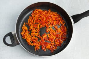 Picture of skillet with carrots and bell pepper.