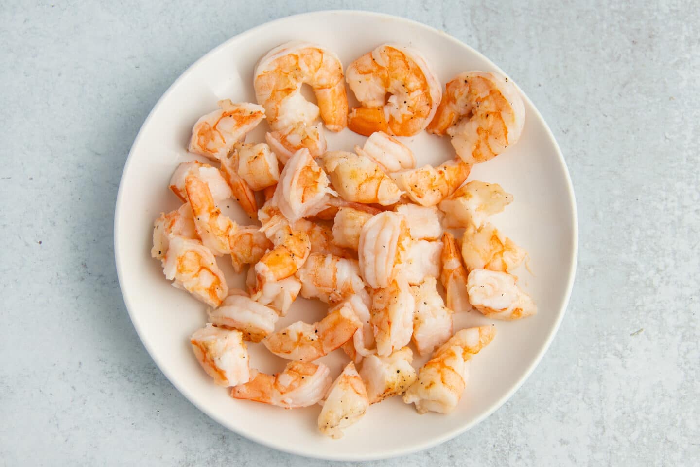 Picture of cooked shrimp on a white plate. 