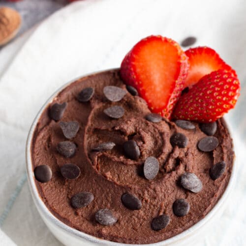 Picture of bowl with dark chocolate hummus in bowl with chocolate chips and strawberries.
