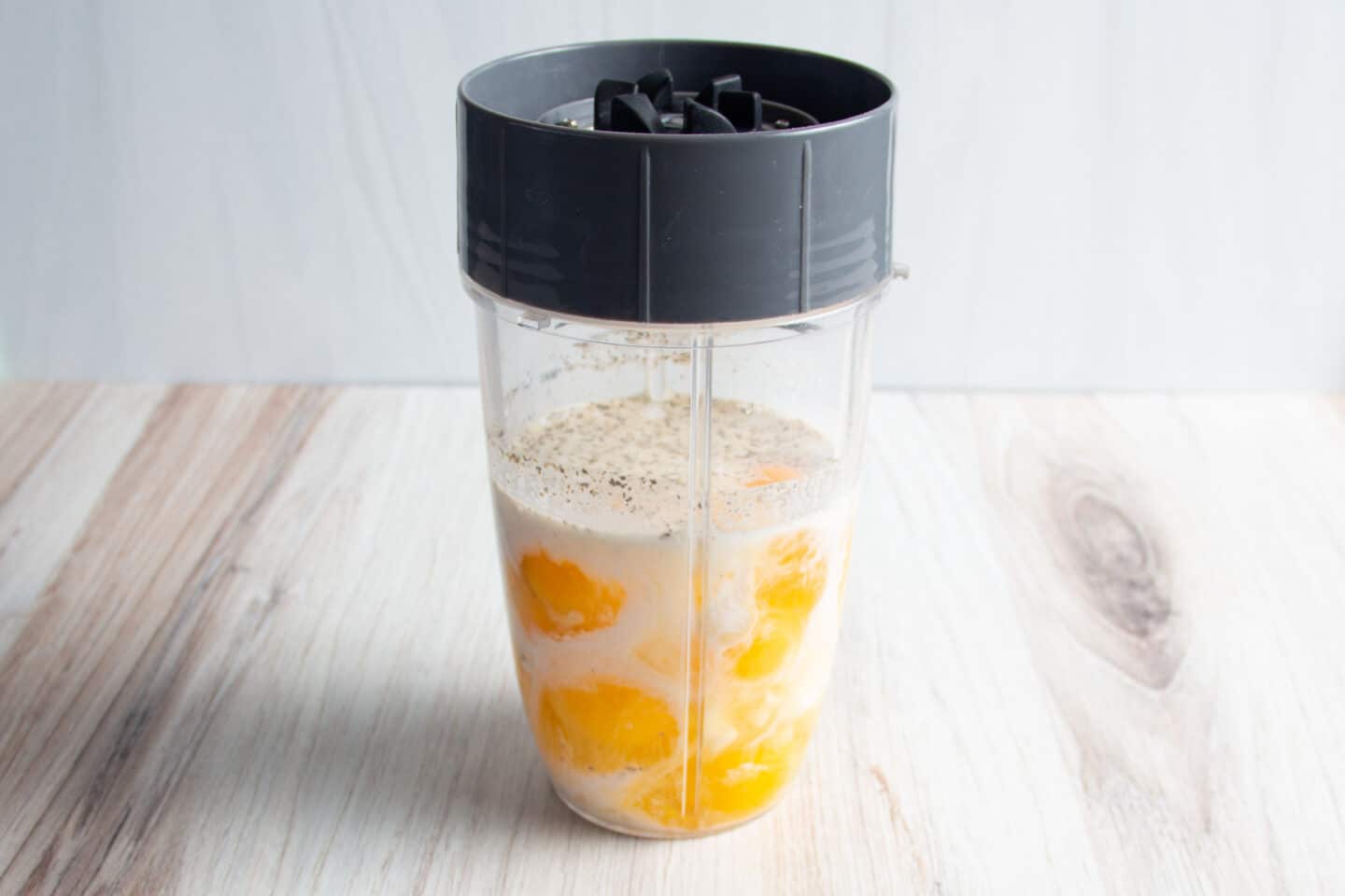 This is a picture of a blender with the eggs, cottage cheese, half and half and seasonings. 