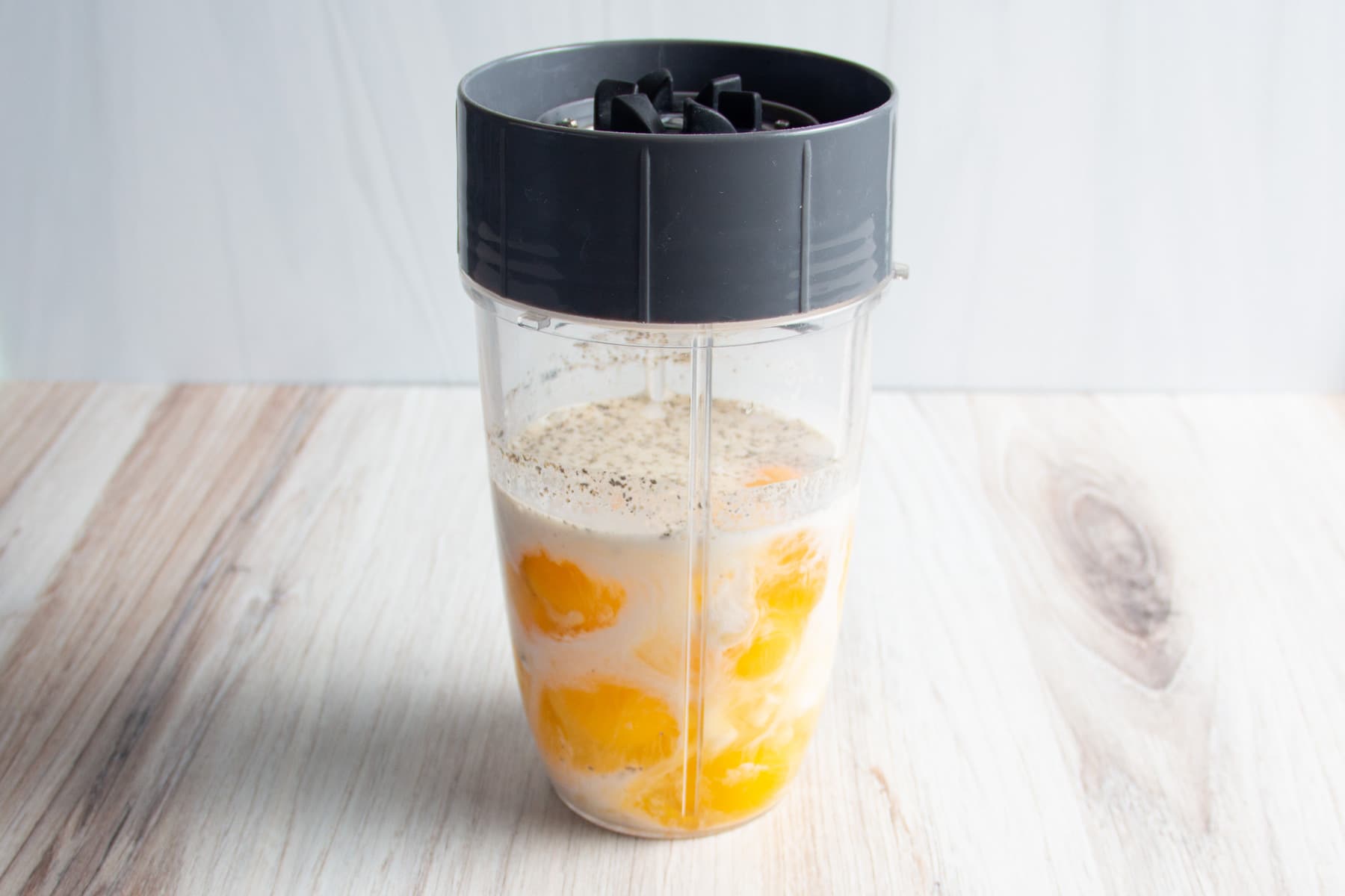 This is a picture of a blender with the eggs, cottage cheese, half and half and seasonings.