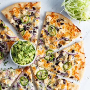 This is a picture of the chicken pizza with black beans and smashed avocado.
