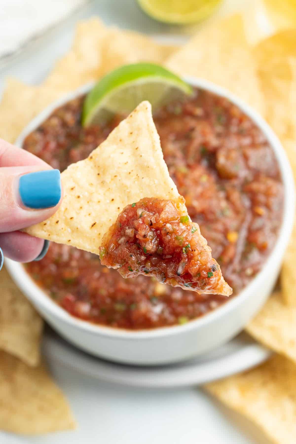 Picture of a tortilla chips with salsa on it. 