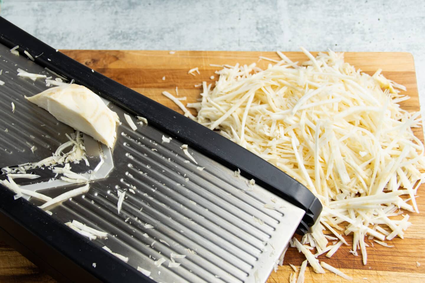 Picture of the celeriac being cut in julienne sticks on the mandoline.