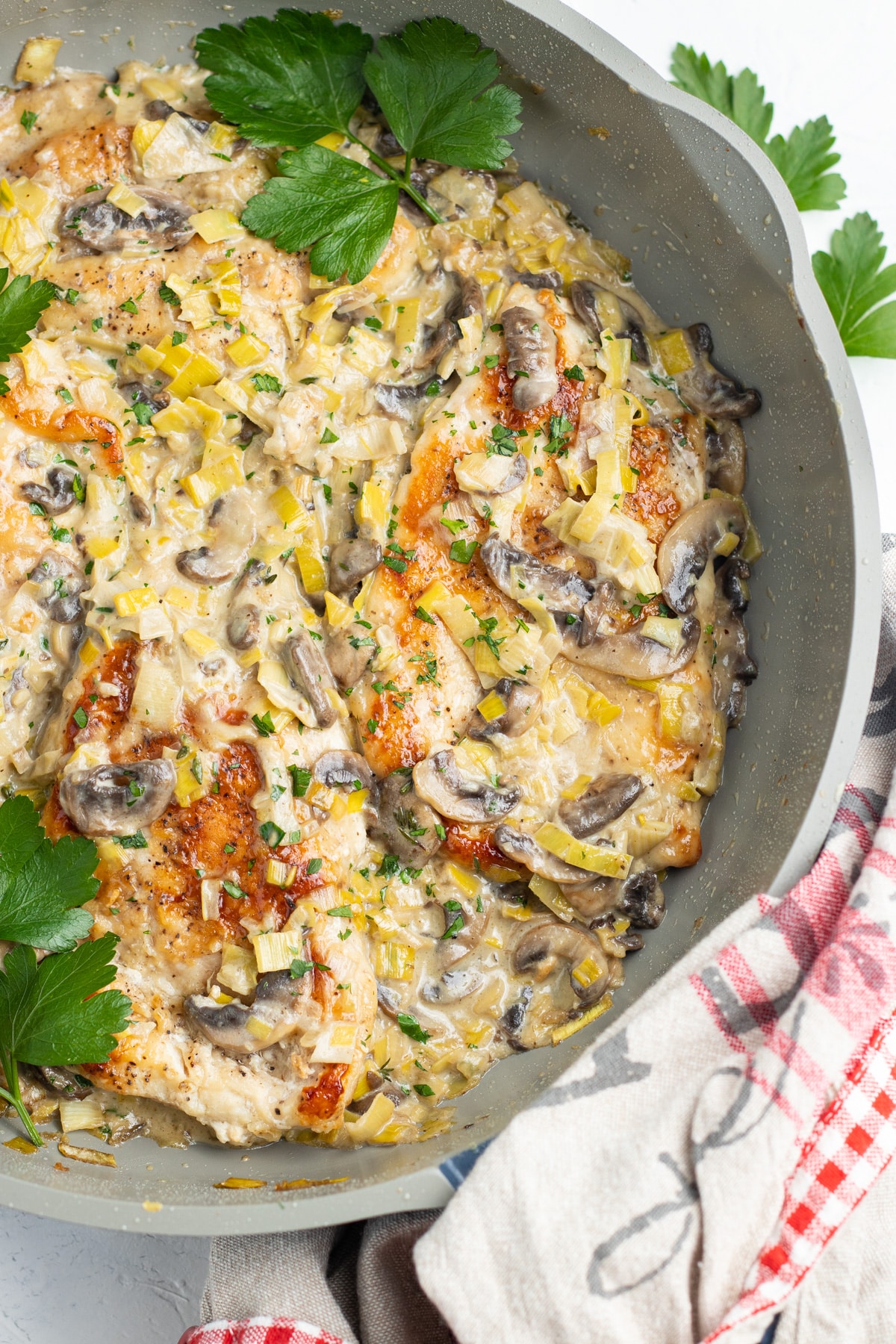 Photo of creamy dijon chicken with mushrooms and leeks close up in the skillet. 