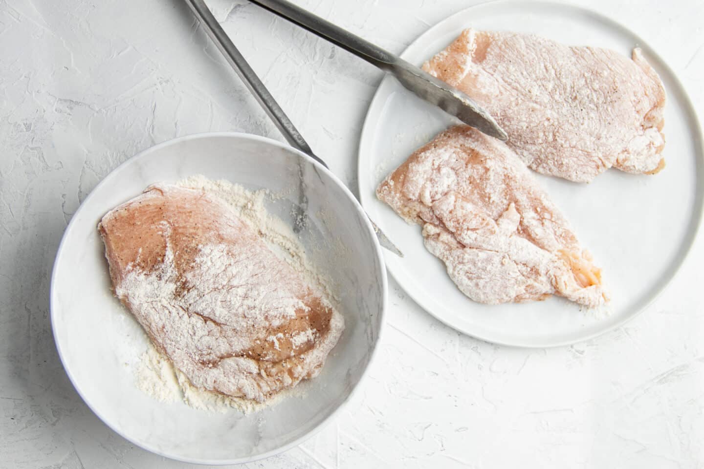 Photo of chicken breast being coated with flour 