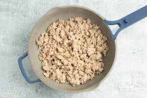 Picture of ground chicken being cooked into skillet.