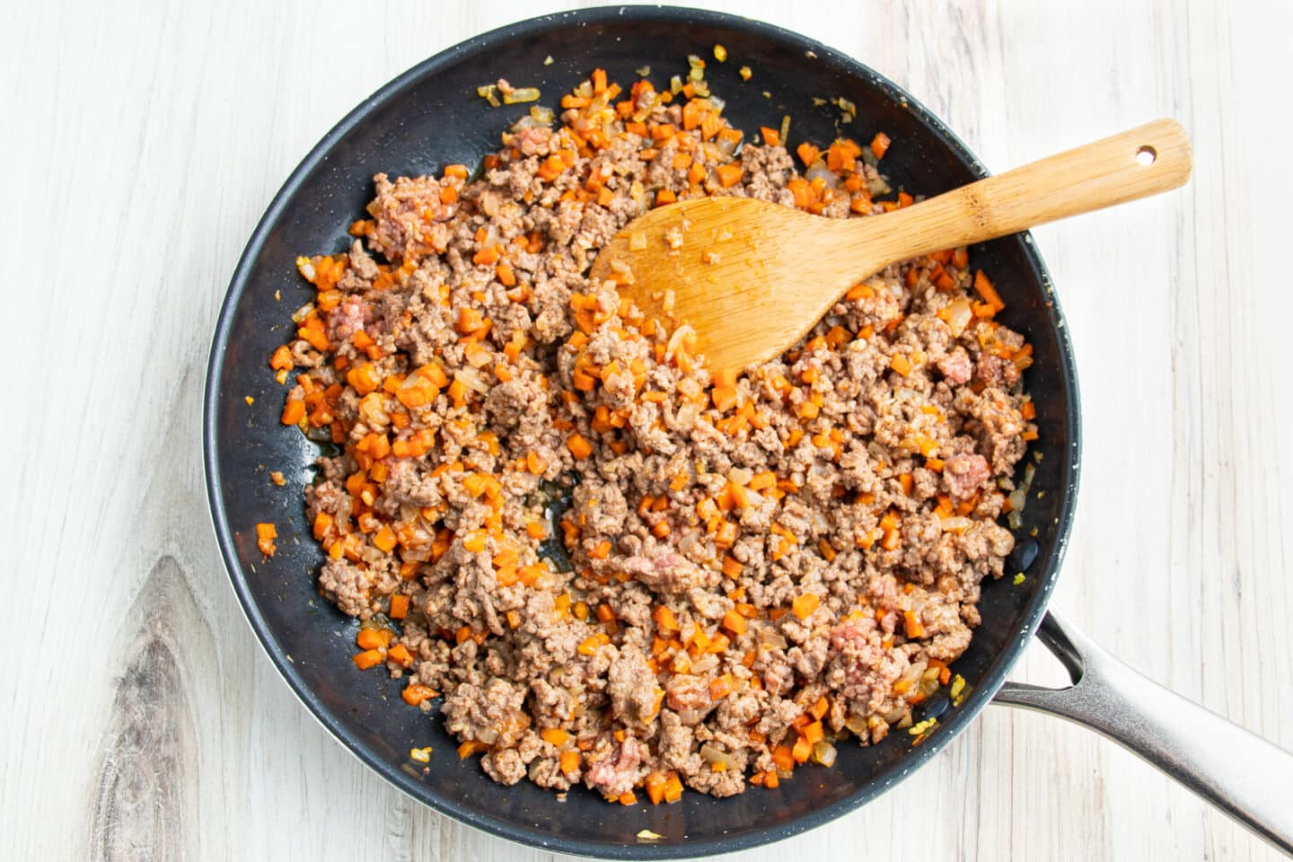 Picture of skillet with veggies and meat cooking.