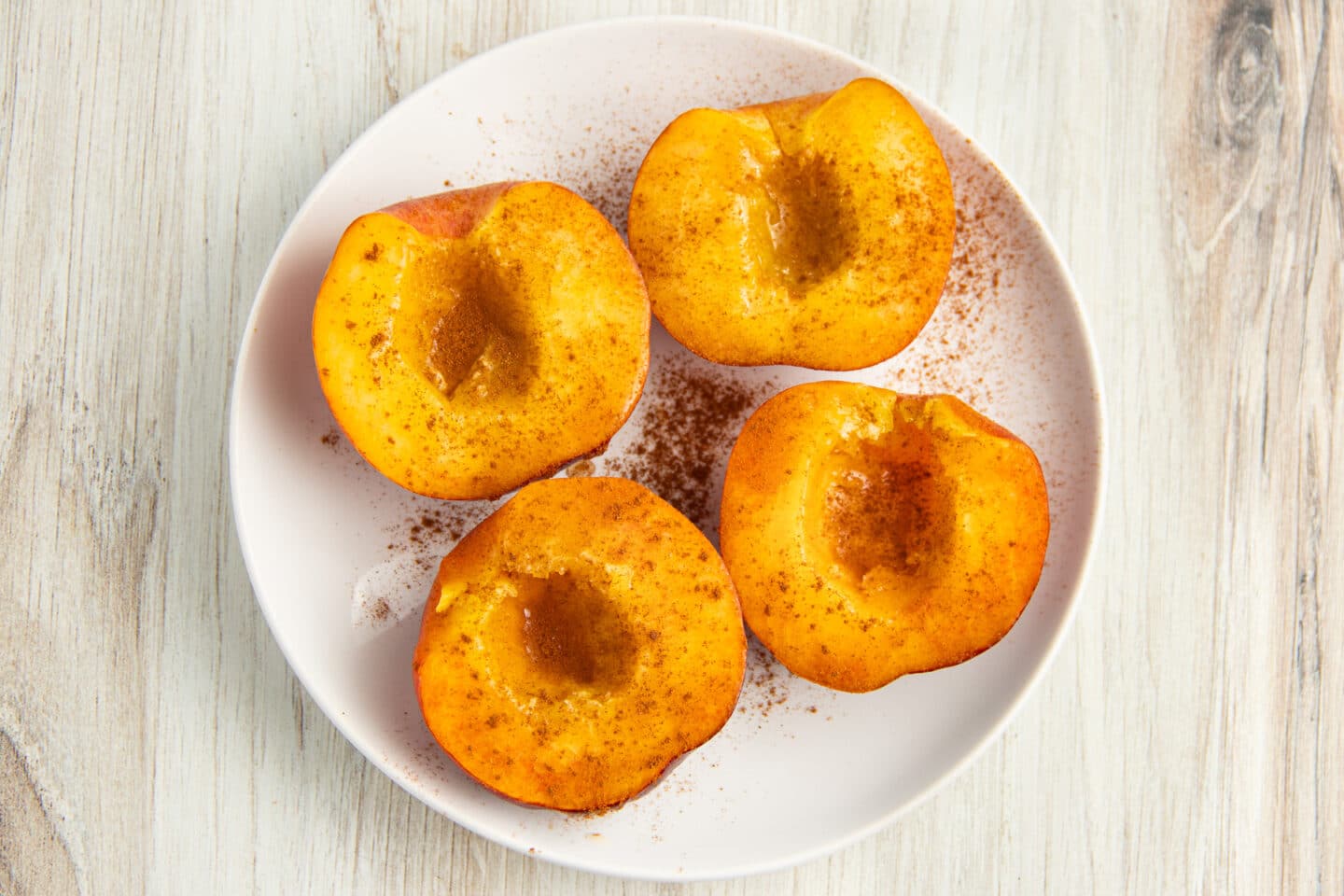 Picture of 4 peach halves seasoned with honey and cinnamon.