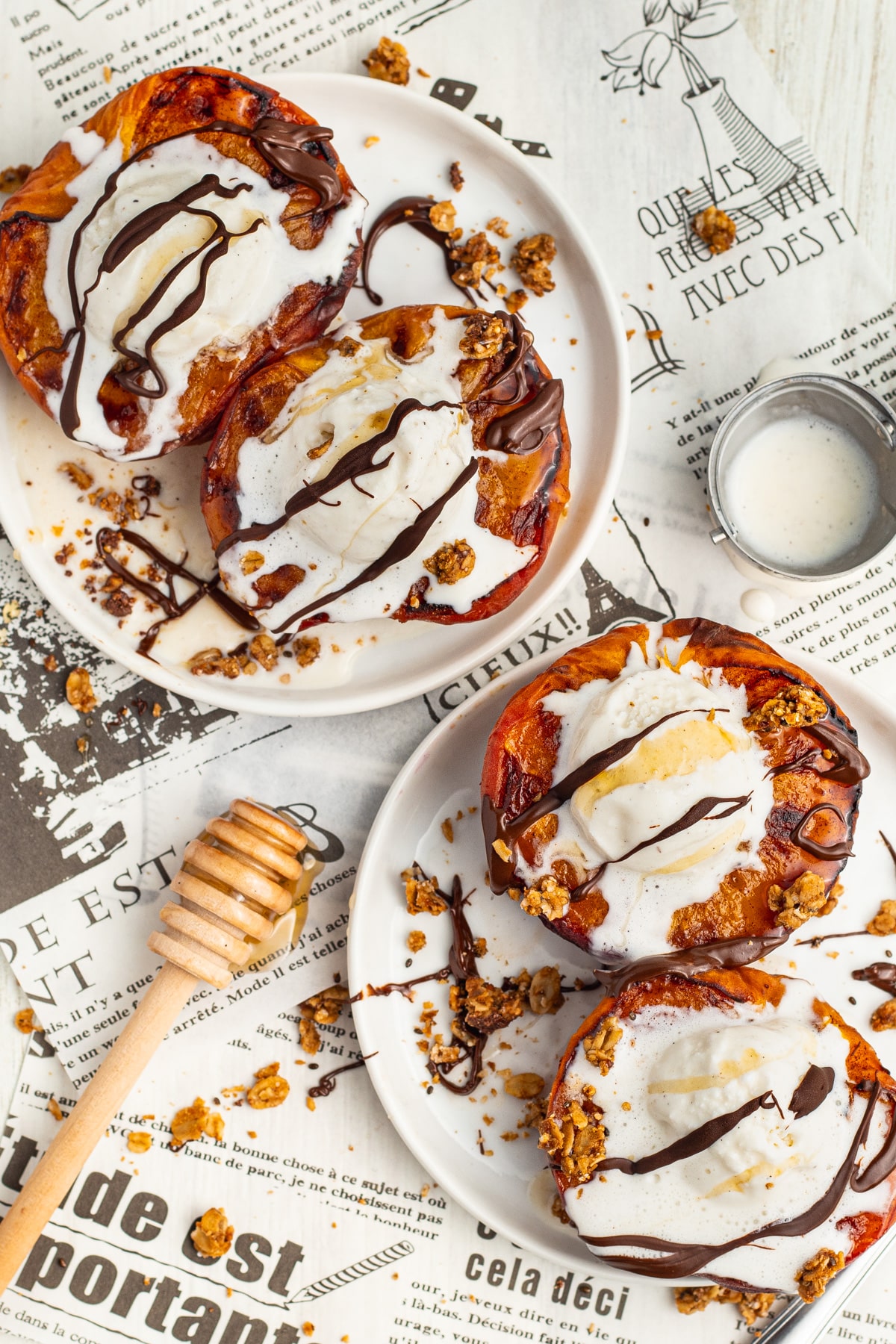 Picture of two plates with air fryer peaches topped with ice cream, chocolate and honey.