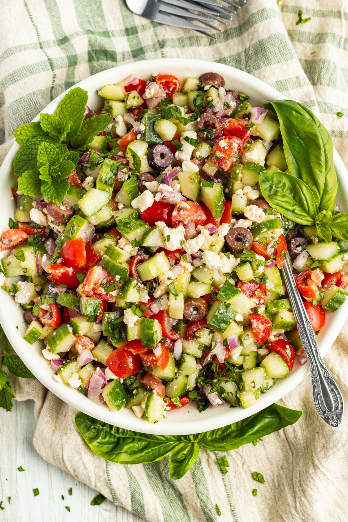 Picture of a white bowl with cucumber salad.
