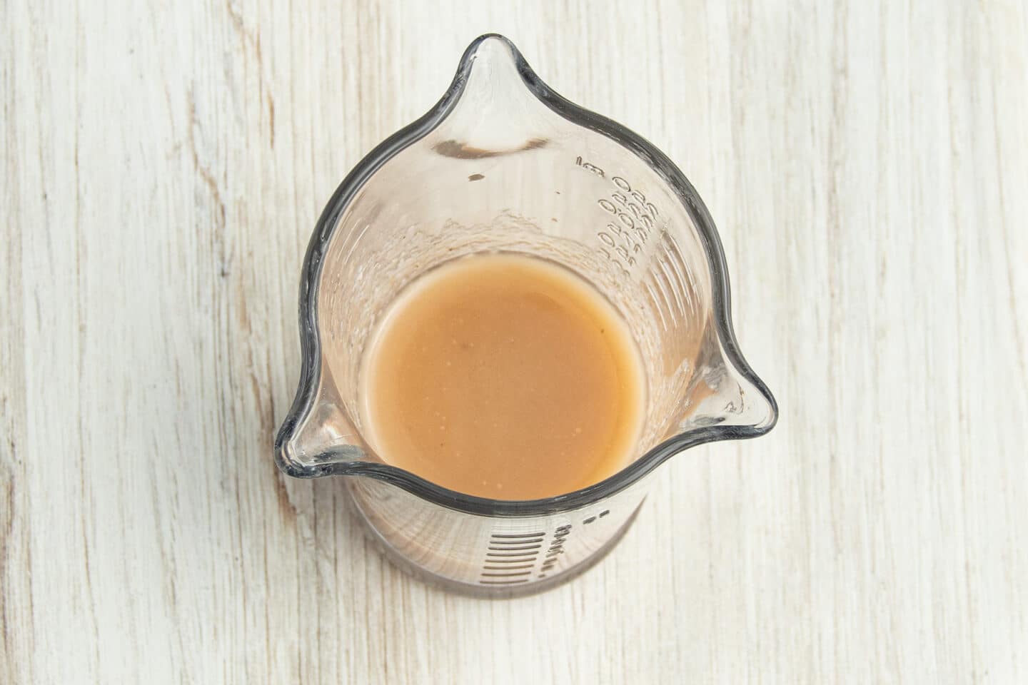 Picture of measuring cup with whisked vinaigrette.