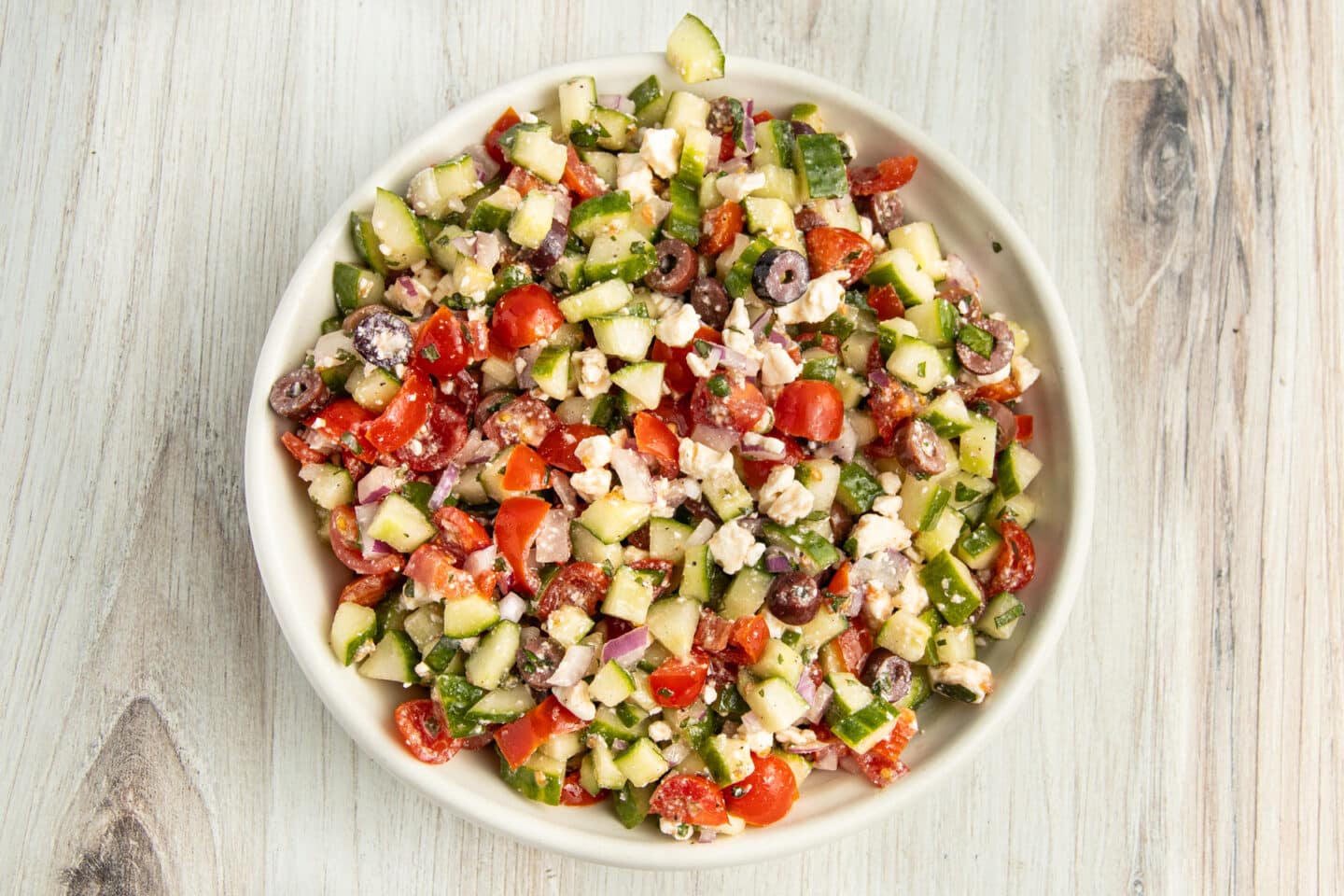 Picture of mediterranean cucumber salad tossed in vinaigrette.