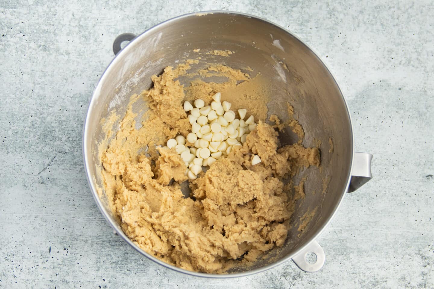 Picture of mixing bowl with mixture and added white chocolate chips.