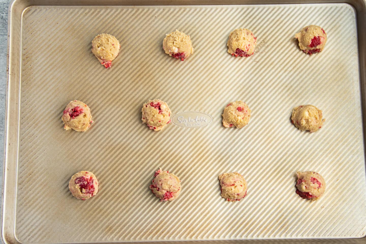 Picture of baking sheet filled with cookie dough balls.