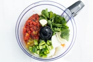 Picture of restaurant-style salsa ingredients in a food processor before blending.