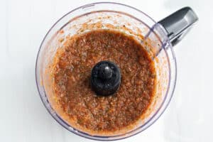 Picture of restaurant-style salsa ingredients in a food processor after blending.