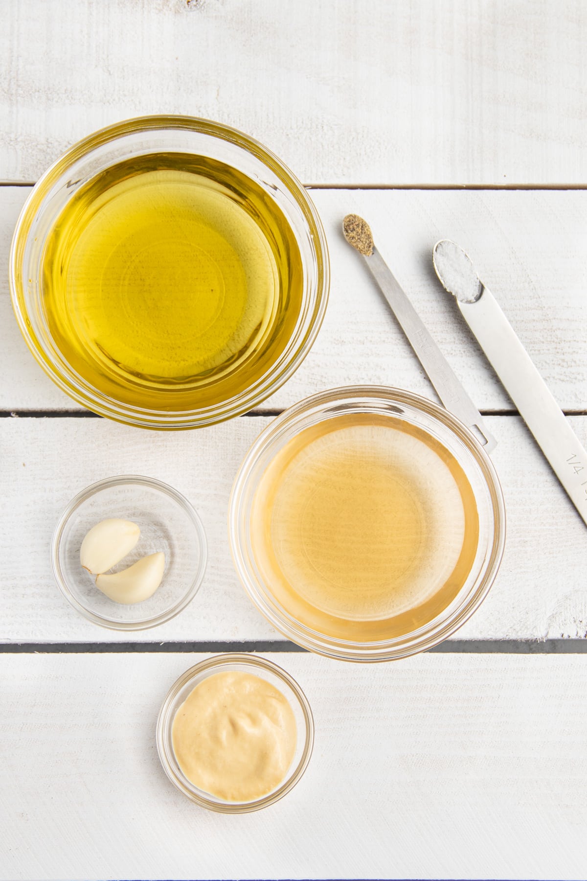 Picture of all ingredients to make champagne vinaigrette in individual bowls.