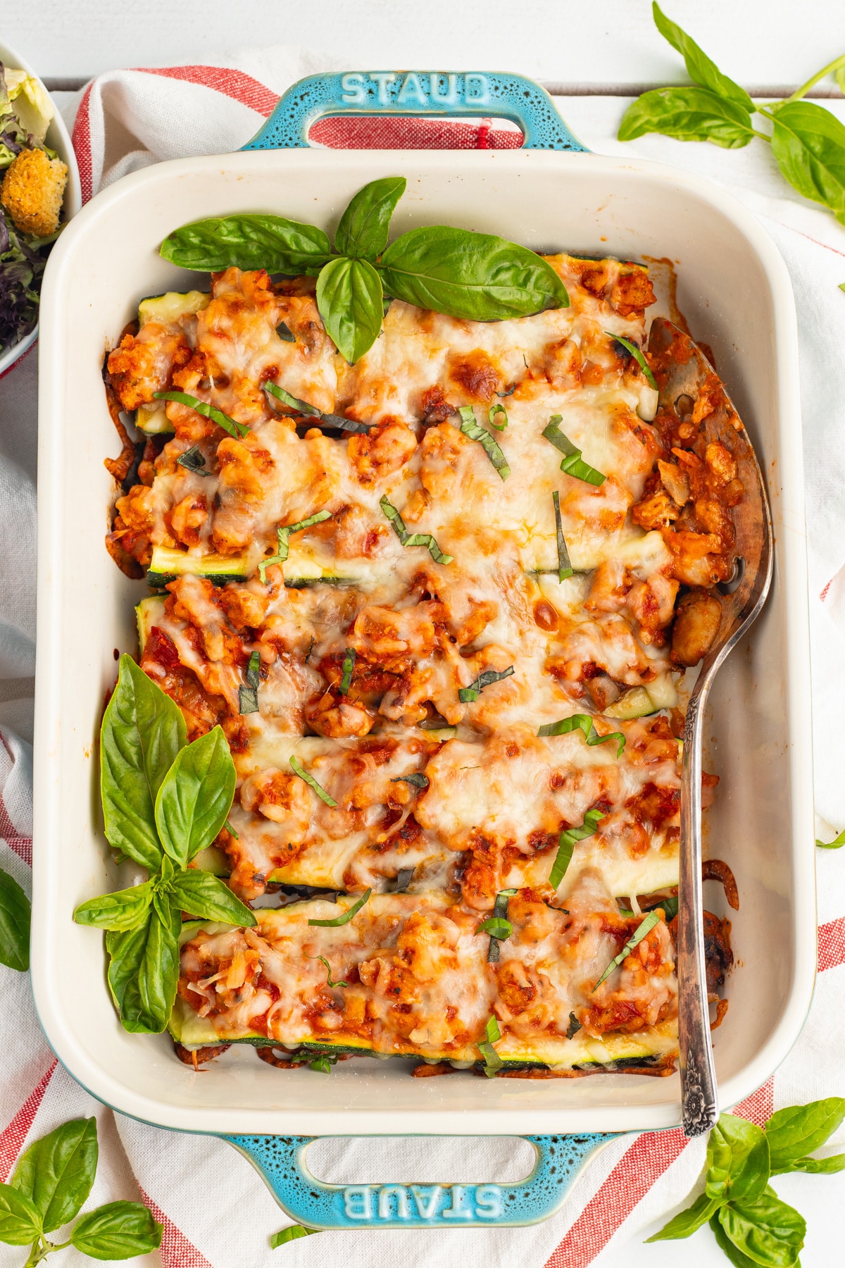 Picture of cooked chicken zucchini boat in baking dish. 