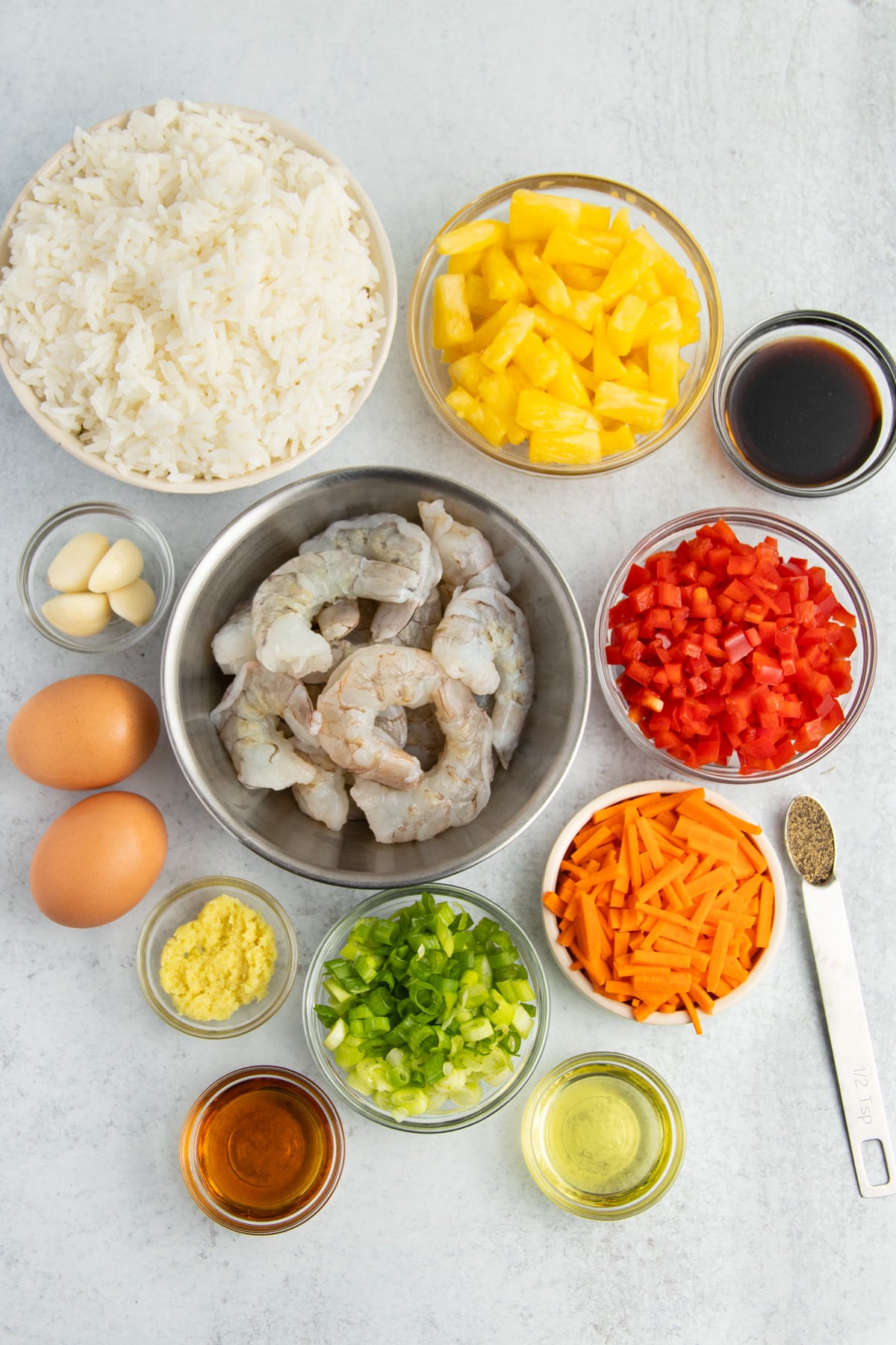 Picture of all ingredients in individual bowls to make shrimp pineapple fried rice.