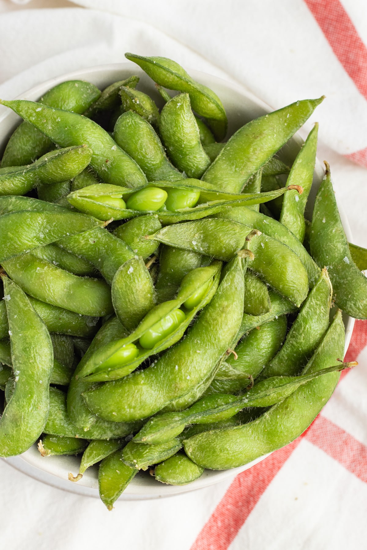 This is a picture of a bowl filled with air fried edamame. 