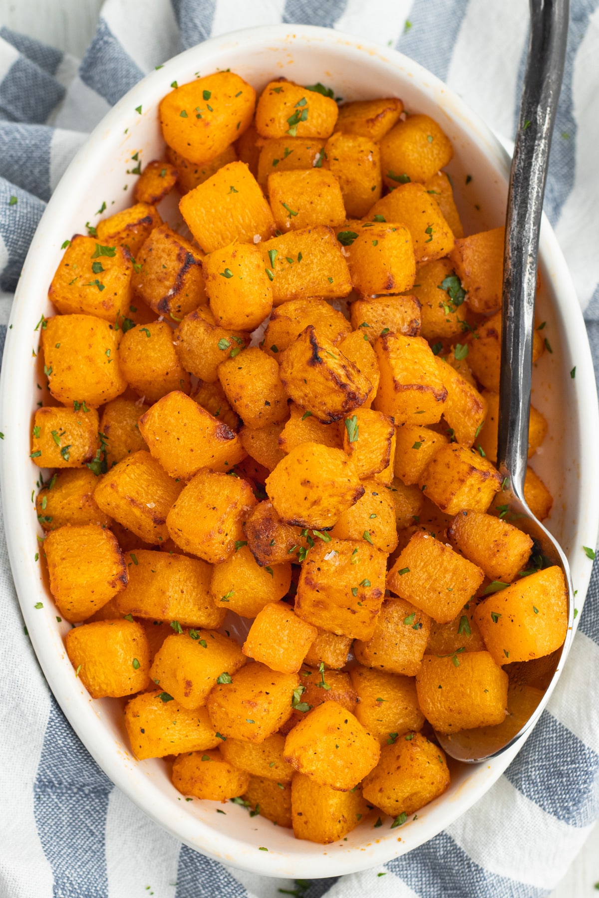 This is a picture of an oval dish filled with cooked butternut squash.