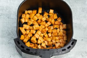Picture of the air fryer with potatoes before cooking.