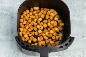 Picture of the air fryer with potatoes after cooking.