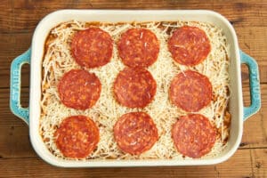 This is a picture of the baking dish with the chicken and squash mixture, cheese and pepperoni on top.
