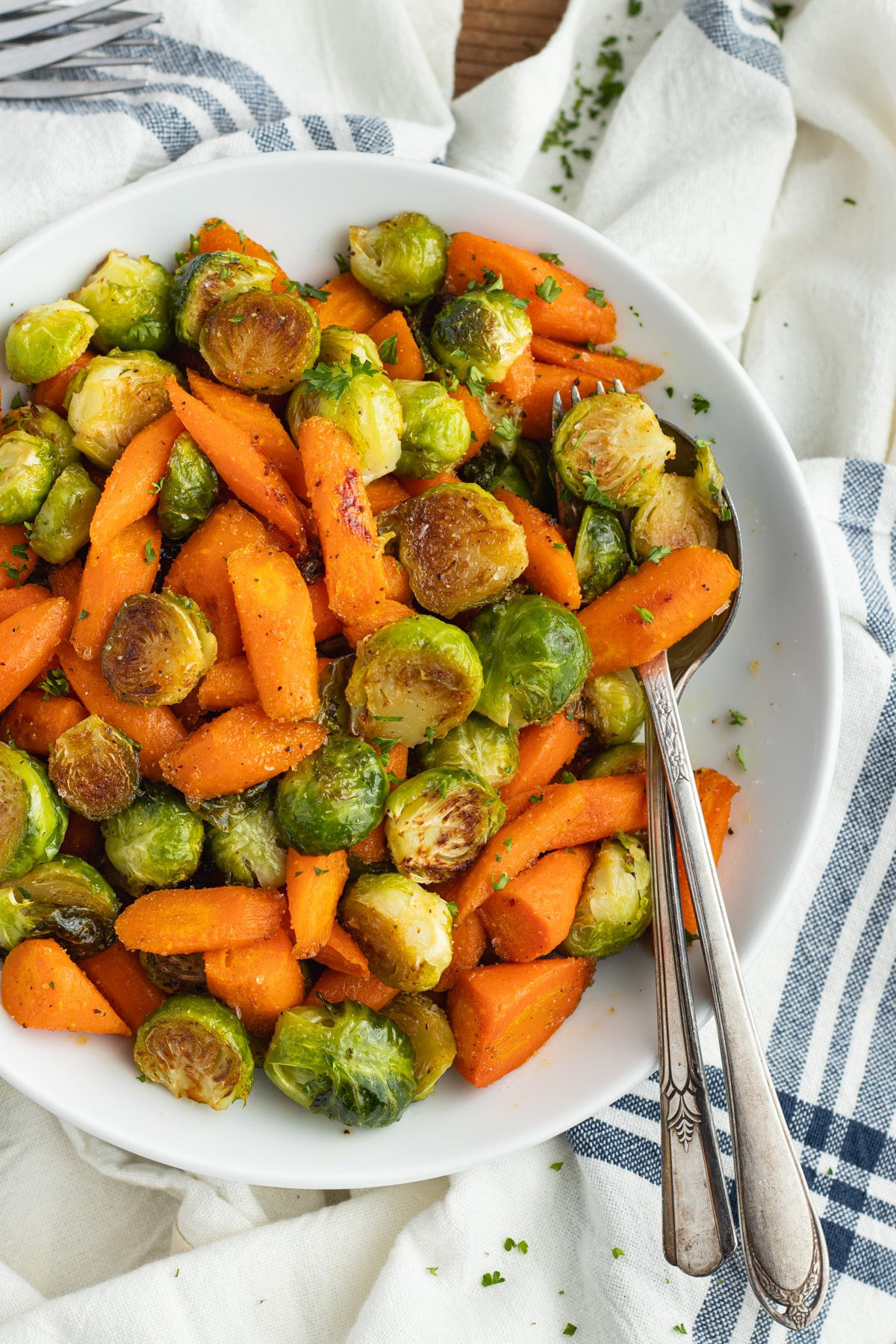 This is a picture of a plate filled with roasted Brussels sprouts and carrots with hot honey.