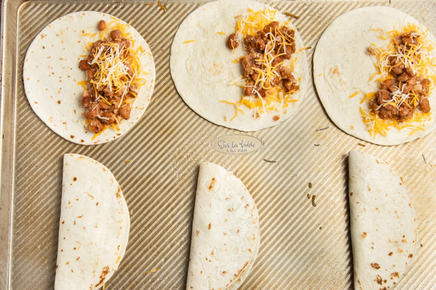 This is a picture of the tortillas being filled with bean and cheese.