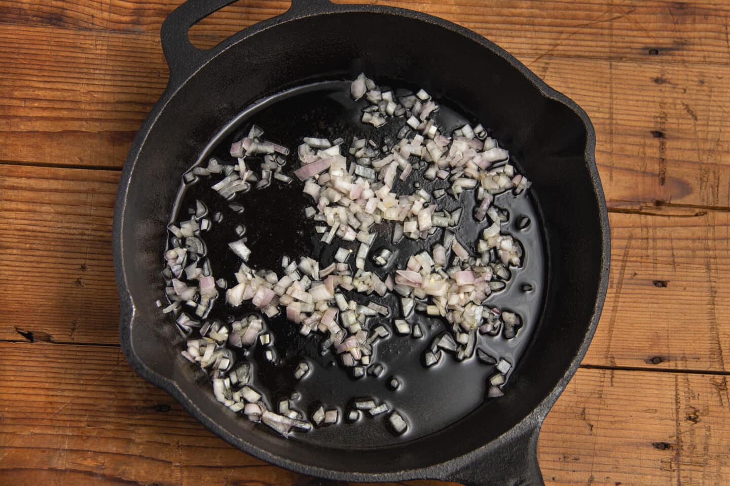 This is a picture of a skillet with shallots cooking.
