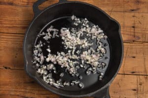This is a picture of a skillet with shallots cooking.