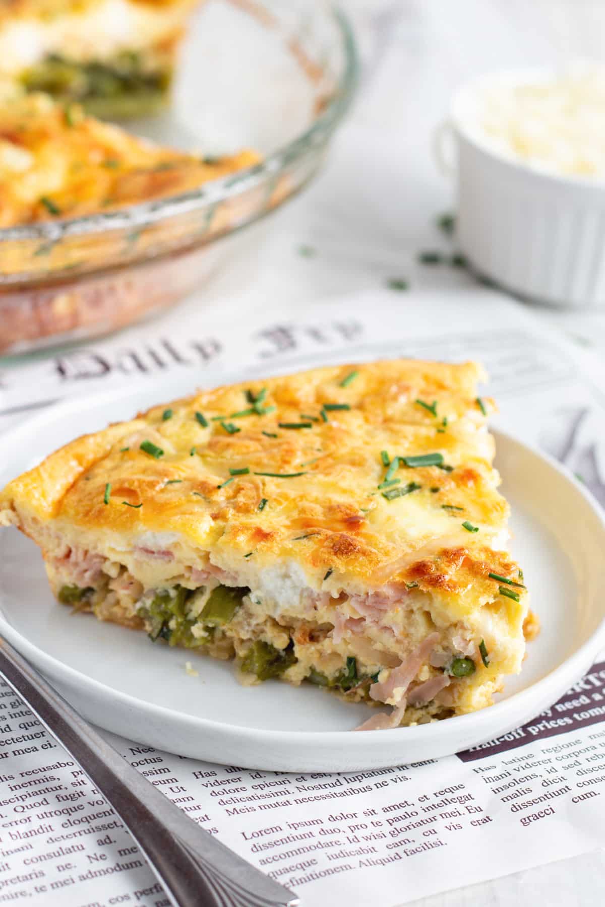 This is a picture of a slice of crustless quiche with asparagus, ham and goat cheese. 