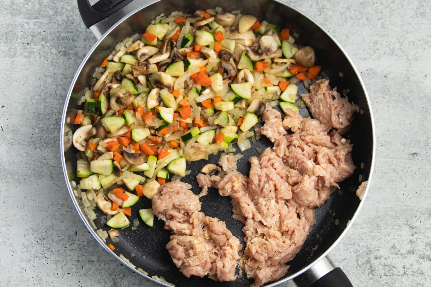 This is a picture of a skillet with the veggies and ground chicken added.