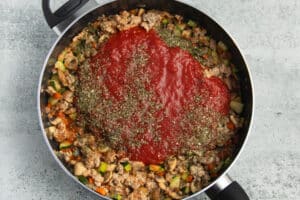 This is a picture of the skillet with crushed tomatoes and spices added.