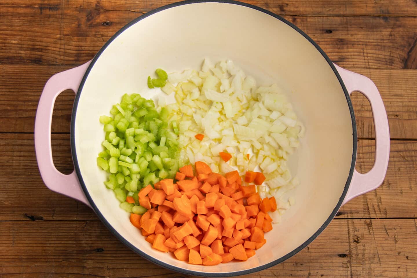 This is a picture of a large pot with carrots, onions and celery.