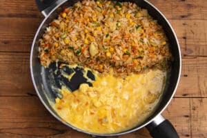 This is a picture of the rice cooking in a skillet, with the eggs added and being scrambled.