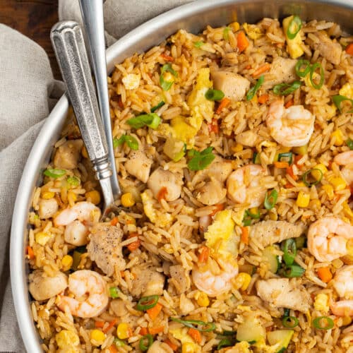 This is a square picture of the chicken and shrimp fried rice in a skillet.