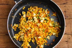 This is a picture of the veggies with added corn cooking in a skillet.
