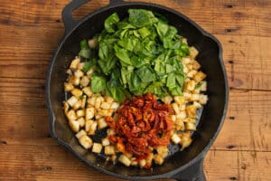 This is a picture of the skillet with added spinach and sun-dried tomatoes.