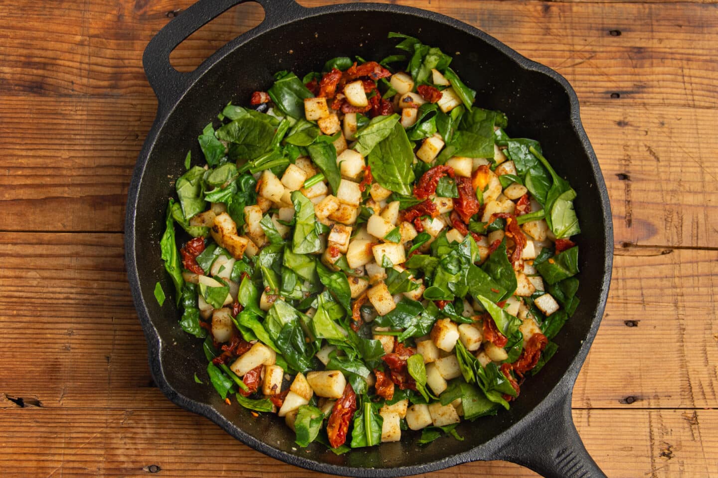 This is a picture of the skillet with added spinach and sun-dried tomatoes mixed in.