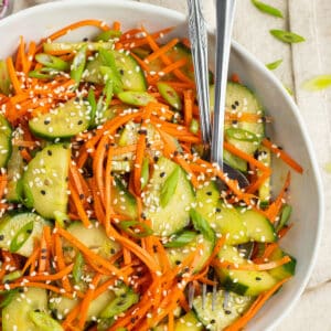 This is square picture of cucumber and carrot salad in a bowl.