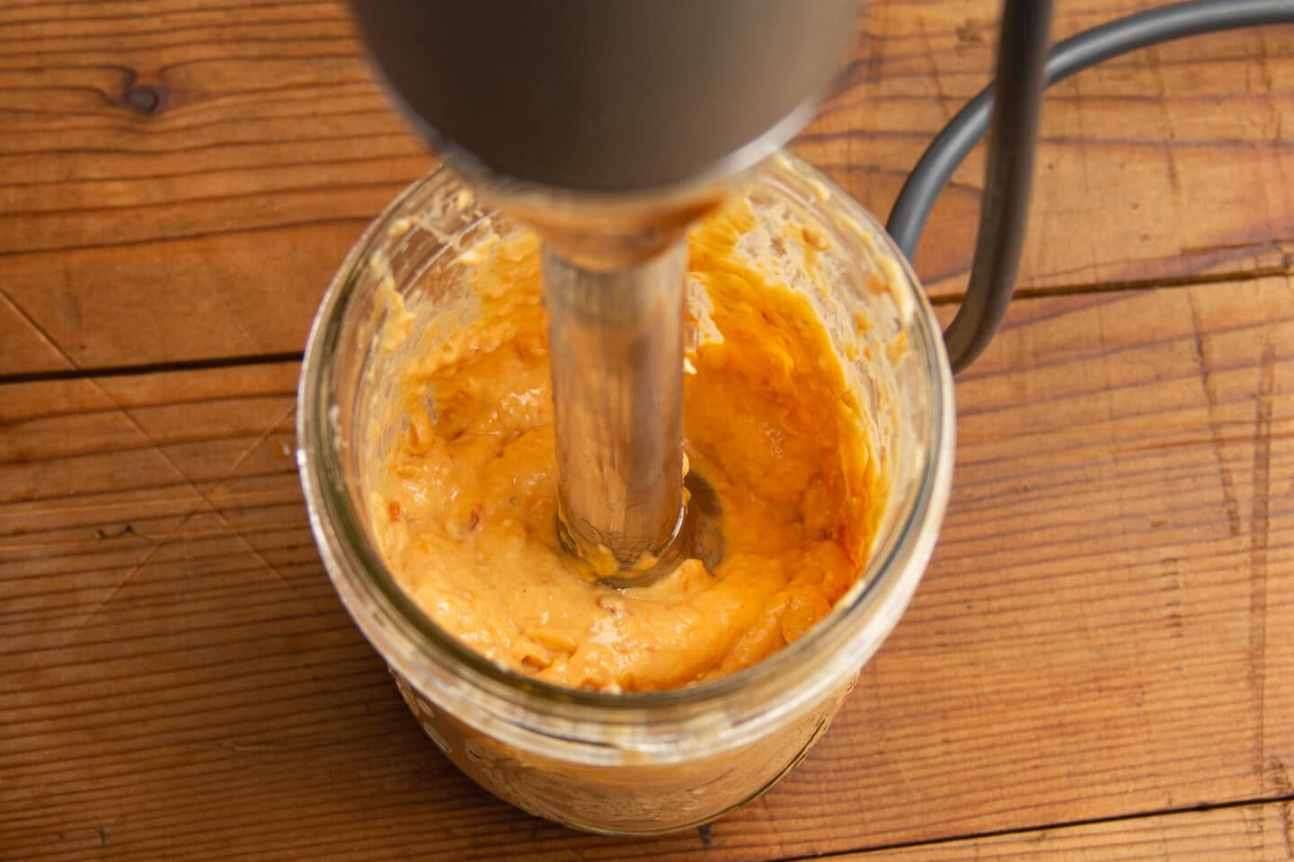 This is a picture of the aioli being blended with an immersion blender.